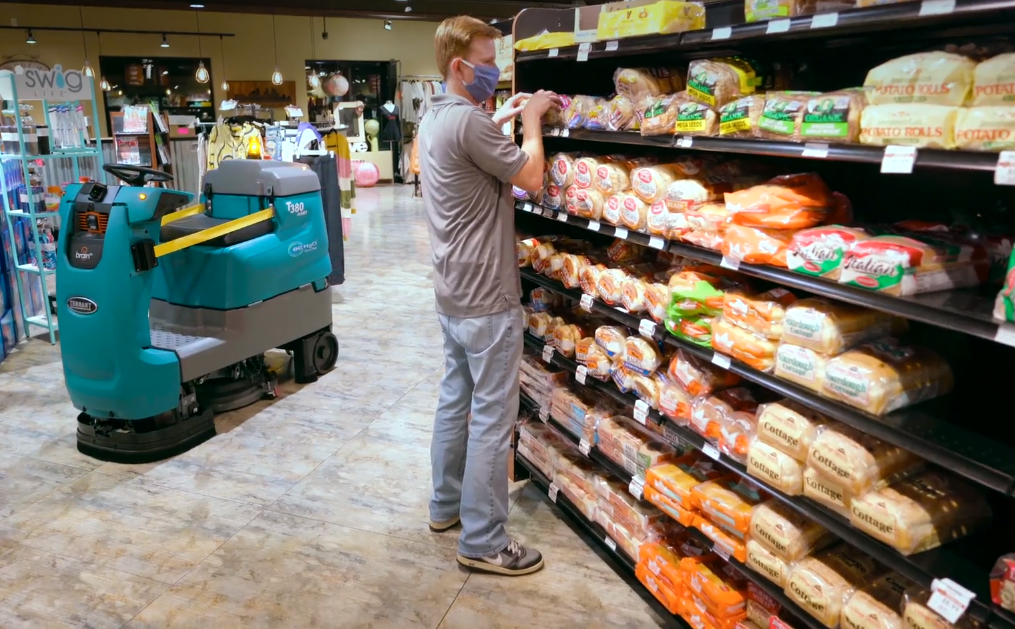 Récureuse à plancher robotisée T380AMR Tennant nettoyant une petite épicerie et permettant au personnel d’être plus productif