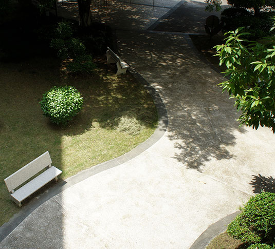 Uma trabalhadora efetua a manutenção de um pavimento de betão polido com uma auto lavadora.